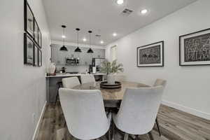 Dining room with light wood finished floors and recessed lighting