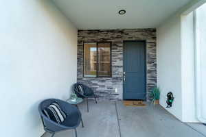 Property entrance featuring stone siding and stucco siding