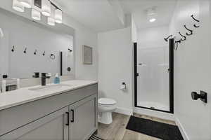 Bathroom featuring a stall shower, vanity, and light wood finished floors
