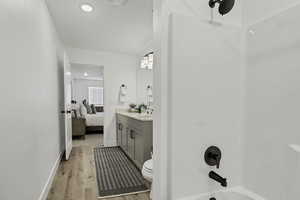 Bathroom featuring vanity, ensuite bath, light wood finished floors, recessed lighting, and shower / bath combination
