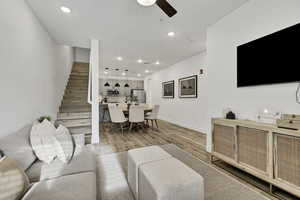 Living area featuring recessed lighting, stairs, light wood-style floors, and ceiling fan