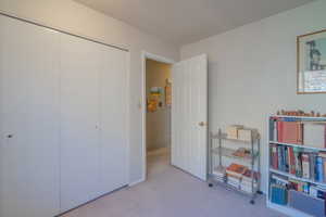 5th Bedroom featuring a textured ceiling, carpet floors, and a closet