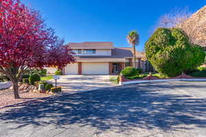 View of front of home with brick siding, driveway, and a tiled roof