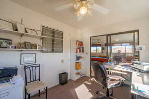 Office with carpet flooring and ceiling fan