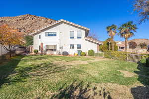Back of property featuring stucco siding, a fenced backyard, and a mountain view