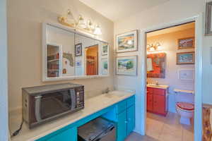 Primary Bathroom with vanity, light tile patterned flooring, and curtained shower
