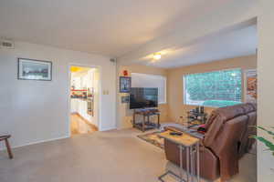 Living area with light carpet and baseboards