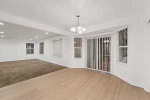 Spare room featuring recessed lighting, a chandelier, and light wood-style floors