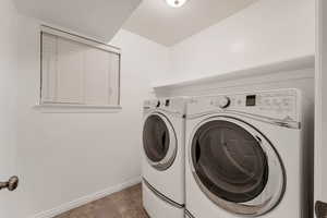 Laundry area featuring baseboards and washing machine and dryer