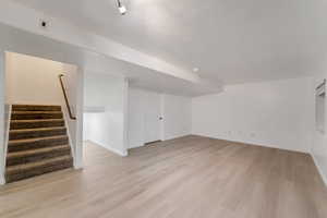 Unfurnished living room with stairs and light wood-type flooring