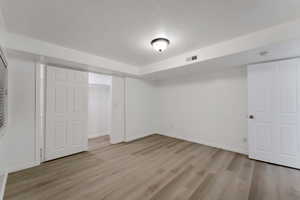 Finished basement featuring light wood finished floors and baseboards