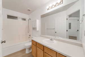 Full bath featuring bathing tub / shower combination, vanity, and light wood-style floors
