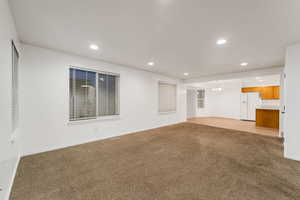 Unfurnished living room with light carpet, recessed lighting, and a chandelier
