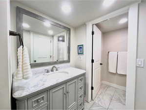 Full bathroom featuring light marble finish flooring, vanity, and a shower with curtain