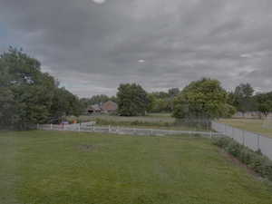 Fenced backyard featuring view of scattered trees