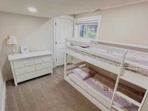 Bedroom with light colored carpet and recessed lighting