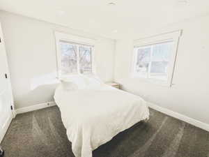 Carpeted bedroom featuring multiple windows and recessed lighting
