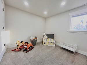 Recreation room with carpet flooring, recessed lighting, and radiator