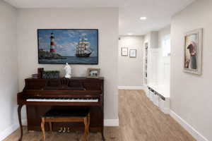 Hallway with light wood-style flooring and recessed lighting