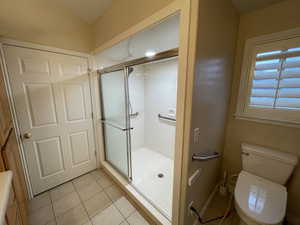 Bathroom with a stall shower and light tile patterned floors
