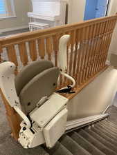 Stairway with carpet flooring and chair lift on stairs