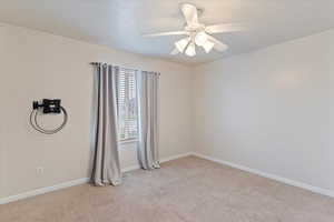 Empty room with light carpet and ceiling fan