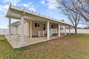 Rear view of house featuring a fenced backyard, a patio area, and a gate