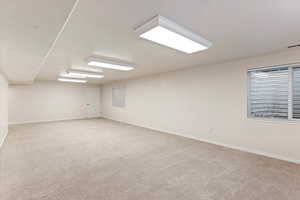 Empty room featuring light carpet and baseboards