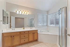 Full bath with a garden tub, double vanity, a stall shower, and light tile patterned floors