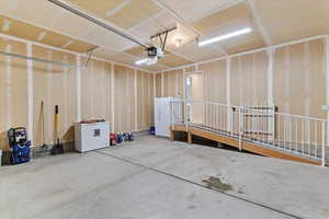 Garage with freestanding refrigerator and white refrigerator