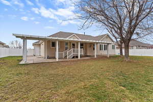 Back of property with a fenced backyard, stucco siding, a shingled roof, and covered porch