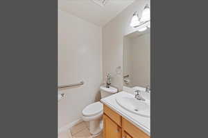 Bathroom with light tile patterned flooring and vanity