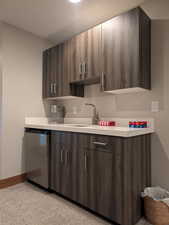Kitchen with light countertops, modern cabinets, stainless steel refrigerator, and dark brown cabinetry