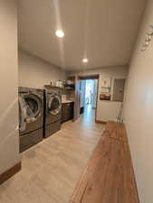 Laundry area featuring independent washer and dryer, electric panel, and recessed lighting