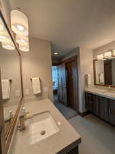 Full bathroom with two vanities, ensuite bathroom, and light tile patterned floors