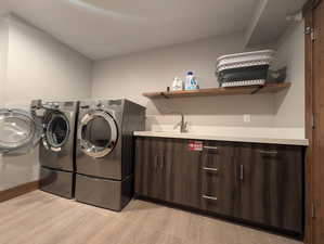 Laundry room featuring washing machine and dryer and light wood-style floors