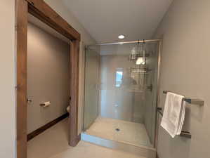Bathroom with a shower stall and tile patterned flooring