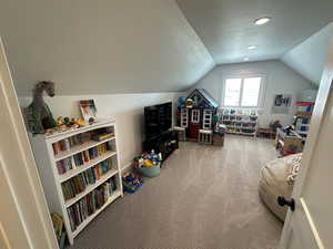 Bonus Room with carpet floors, lofted ceiling, and a textured ceiling