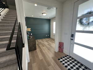 Foyer entrance featuring light wood-style floors, stairs, and recessed lighting