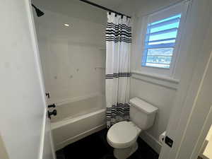 Full bath with shower / bath combo and tile patterned floors
