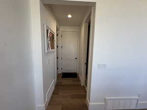 Corridor featuring dark wood-type flooring and recessed lighting
