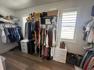 Walk in closet featuring dark wood finished floors