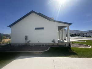 View of side of property featuring a mountain view and a yard