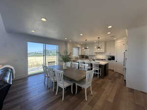 Dining space featuring dark wood-style flooring, a chandelier, and recessed lighting
