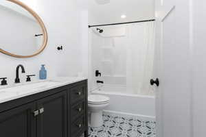 Bathroom with shower / bathtub combination with curtain, vanity, and light tile patterned floors