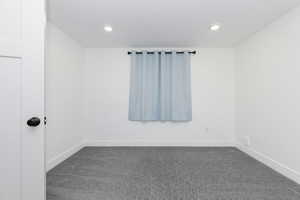 Bedroom with dark carpet and recessed lighting
