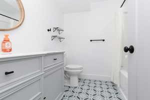 Bathroom featuring shower / bath combination with curtain, vanity, and light tile patterned floors