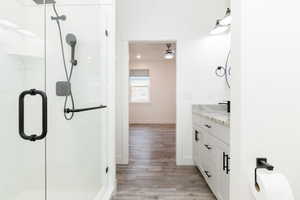 Full bathroom with vanity, light wood-style floors, and a stall shower