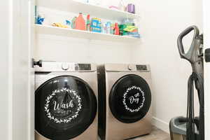 Washroom featuring washing machine and dryer and wood finished floors