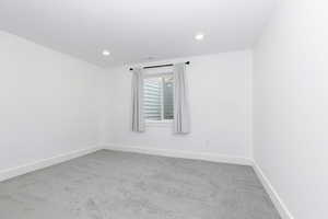 Bedroom with light colored carpet and baseboards